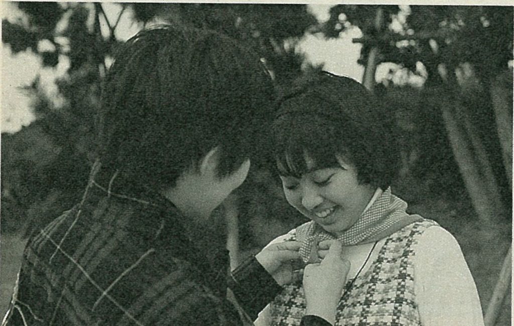 Megumi Ogata ties a red scarf around Natsuko's neck